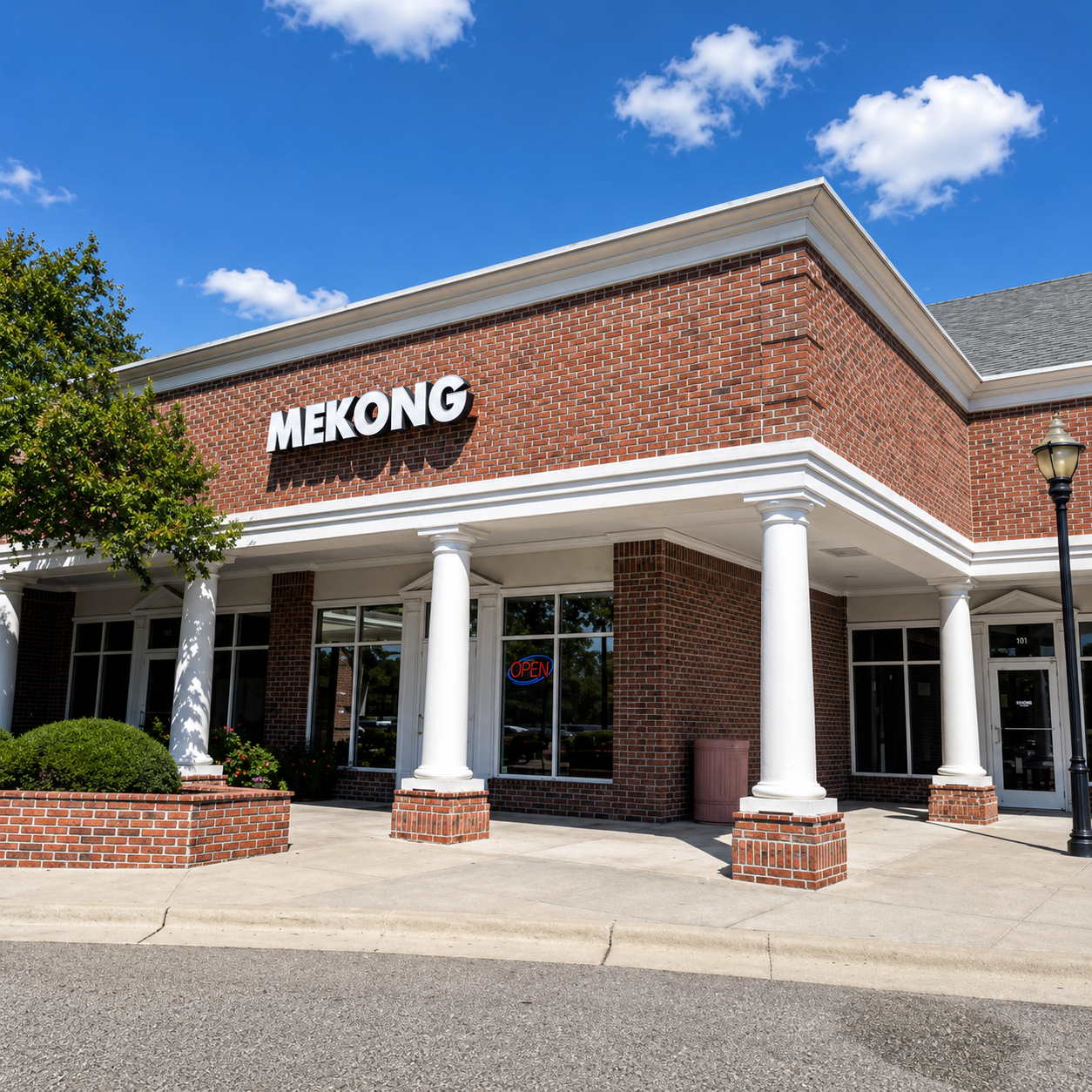 Corner exterior view of the restaurant with white columns, brick facade, and blue sky above.
